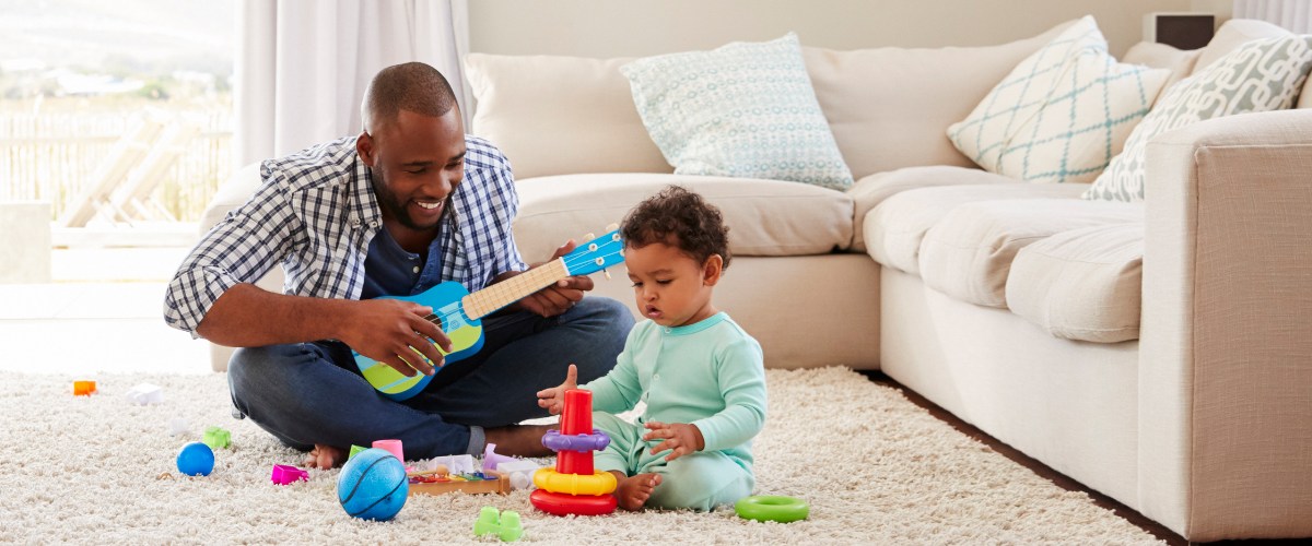 Father and son playing with toys on the ground